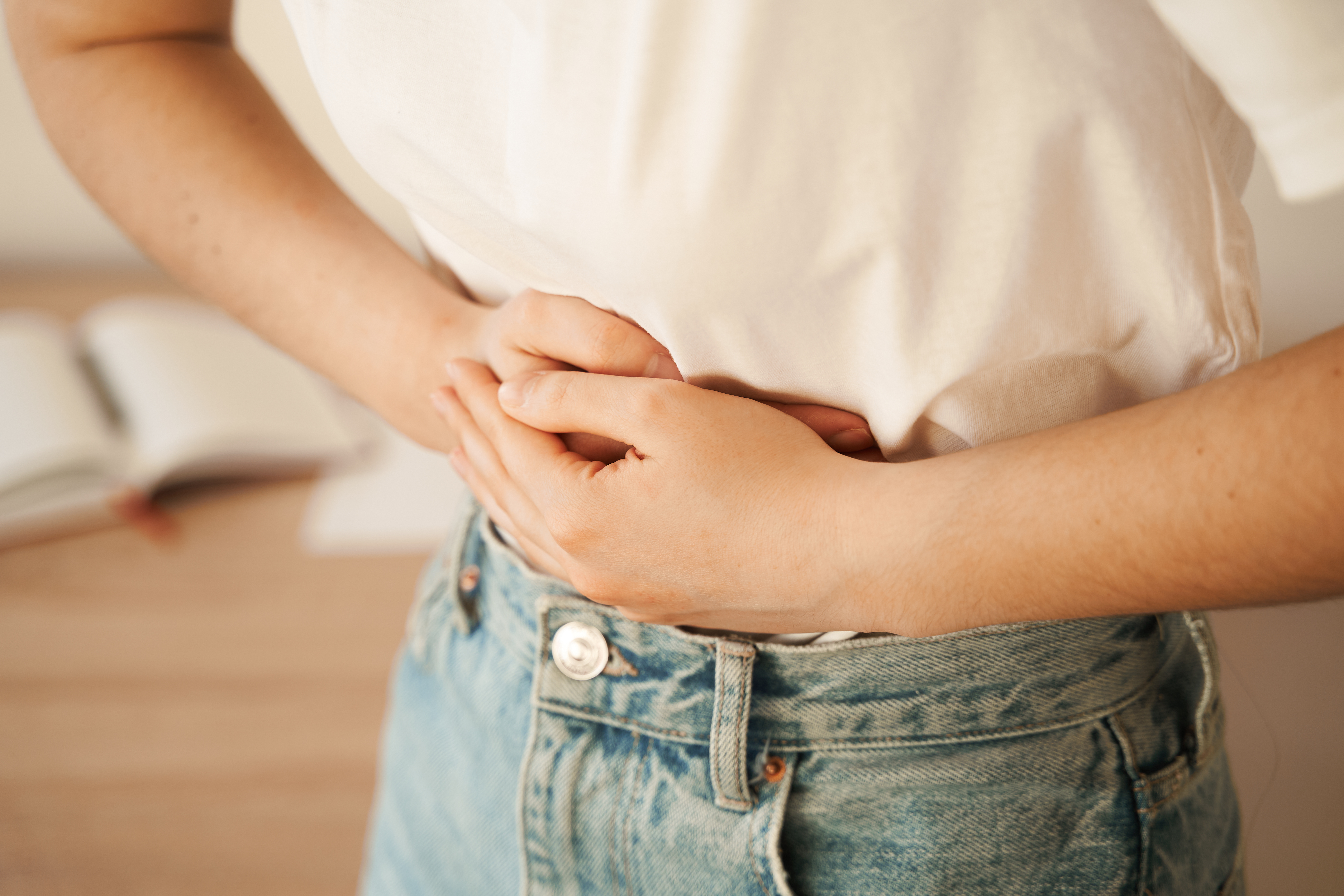 Frau hält sich die Hände vor den Bauch.